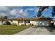 Charming one-story home featuring a manicured front lawn, and an attached garage at 1462 Highfield Dr, Clearwater, FL 33764