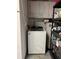 Practical laundry room with a white washing machine and storage shelves for organization at 1462 Highfield Dr, Clearwater, FL 33764