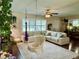 Inviting living room with a large sectional couch, bright windows, and unique hanging chairs at 1462 Highfield Dr, Clearwater, FL 33764
