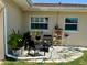 Cozy patio area with stylish seating, surrounded by lush plants, ideal for relaxation and small gatherings at 1462 Highfield Dr, Clearwater, FL 33764