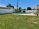 Backyard featuring a private pool, surrounded by a well-maintained lawn and a white privacy fence at 1462 Highfield Dr, Clearwater, FL 33764