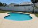 Backyard swimming pool featuring a curved design with a paved deck and a private fenced-in yard, ideal for relaxing at 1462 Highfield Dr, Clearwater, FL 33764