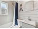 Clean bathroom with white tiles, modern sink, and stylish mirror, with nautical decorations at 1529 Essex N Dr, St Petersburg, FL 33710