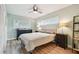 Serene bedroom featuring a comfortable queen bed, wood floors, and ample natural light at 1529 Essex N Dr, St Petersburg, FL 33710