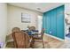 Cozy dining area featuring light walls, wood floor, blue accent wall, and a glass table with wicker chairs at 1529 Essex N Dr, St Petersburg, FL 33710
