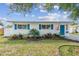 Charming single-story home features bright blue shutters and a neatly landscaped front yard with an American flag at 1529 Essex N Dr, St Petersburg, FL 33710