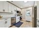 Bright kitchen featuring white cabinets, stainless steel appliances, and wood-style flooring at 1529 Essex N Dr, St Petersburg, FL 33710