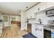 Modern kitchen with stainless steel appliances, white cabinets, and hardwood floors at 1529 Essex N Dr, St Petersburg, FL 33710