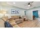 Cozy living room with plush sectional sofa, wood floors, and light green walls at 1529 Essex N Dr, St Petersburg, FL 33710