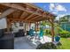 Outdoor dining area with wooden pergola, seating, and backyard views at 1529 Essex N Dr, St Petersburg, FL 33710