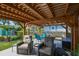 Outdoor seating beneath a wooden pergola, surrounded by plants and greenery at 1529 Essex N Dr, St Petersburg, FL 33710