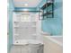 Bathroom features white tile floor and shower with blue walls and modern shelving at 1569 Larkin Rd, Spring Hill, FL 34608