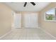 Bright bedroom with tile floors, large window, ceiling fan and a closet offers a comfortable and functional space at 1569 Larkin Rd, Spring Hill, FL 34608