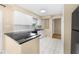Well-lit kitchen with white cabinets, granite countertops, and tile flooring at 1569 Larkin Rd, Spring Hill, FL 34608