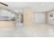 Bright living room with tile floors open to the kitchen with white cabinets and black countertops at 1569 Larkin Rd, Spring Hill, FL 34608