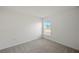 Bright, airy bedroom featuring a neutral-toned carpet, white walls, and a window with blinds at 1637 Birchcrest Blvd, Port Charlotte, FL 33952