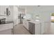 Modern kitchen featuring white cabinetry, stainless steel appliances, and a center island with sink at 1637 Birchcrest Blvd, Port Charlotte, FL 33952