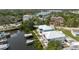 Aerial view of waterfront homes featuring docks and boat lifts on a canal, surrounded by lush landscaping at 216 High St, Tarpon Springs, FL 34689