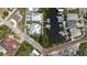 Overhead view of waterfront homes with boat docks, surrounded by mature trees and a brick road at 216 High St, Tarpon Springs, FL 34689