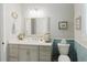 Bright bathroom with a white vanity, decorative mirror, and blue tiled backsplash at 216 High St, Tarpon Springs, FL 34689