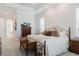 Well-lit bedroom with decorative bed frame, a sitting bench, and beautiful hard wood furniture at 216 High St, Tarpon Springs, FL 34689