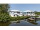 Waterfront home featuring a dock, boat lift, covered patio, and stairs leading to a porch at 216 High St, Tarpon Springs, FL 34689