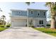 Image of the property's exterior, featuring a garage, a well-manicured lawn, and a light blue facade at 216 High St, Tarpon Springs, FL 34689