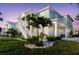 Elegant coastal home featuring a ground floor garage, covered porch, and lush, tropical landscaping at 216 High St, Tarpon Springs, FL 34689