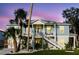 Charming coastal home with double porches, decorative railings, and tropical landscaping at 216 High St, Tarpon Springs, FL 34689