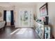 Elegant entryway with hardwood floors, a decorative cabinet, and natural light streaming through the glass front door at 216 High St, Tarpon Springs, FL 34689