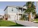 Beautiful two-story home with a garage, palm trees, and landscaped gardens in a pristine setting at 216 High St, Tarpon Springs, FL 34689