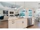 Kitchen island with stainless dishwasher and sink and views of the open floor plan at 216 High St, Tarpon Springs, FL 34689
