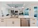 Kitchen island with a sink, dishwasher, and views of the open living area at 216 High St, Tarpon Springs, FL 34689