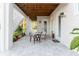 Covered patio with tiled flooring, comfortable seating, and views of the well-manicured backyard at 216 High St, Tarpon Springs, FL 34689