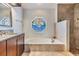 Bathroom featuring dual sinks, wood cabinets, a soaking tub, and a glass-enclosed shower at 2216 Eagle Bluff Dr, Valrico, FL 33596