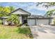 Well-maintained home featuring a two-car garage, elegant entryway, and lush landscaping for added curb appeal at 2216 Eagle Bluff Dr, Valrico, FL 33596
