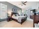 Cozy main bedroom with neutral tones, dark wood furniture, fan, and sliding glass door to outdoor patio at 2216 Eagle Bluff Dr, Valrico, FL 33596