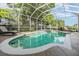 Screened-in pool and hot tub features lush landscaping and sunny skies, providing a luxurious outdoor oasis at 2216 Eagle Bluff Dr, Valrico, FL 33596