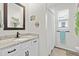 Bright bathroom featuring a granite countertop, white vanity, and a shower with a curtain at 2401 Morninglight Dr, Lutz, FL 33558