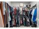 Walk-in closet with wire shelving and hanging rods filled with an assortment of clothing at 2401 Morninglight Dr, Lutz, FL 33558
