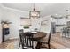 Dining area with a round wooden table, decorative lighting, and a view into the modern kitchen at 2401 Morninglight Dr, Lutz, FL 33558