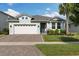 Charming single-story home with a two-car garage, paver driveway, and well-maintained lawn at 2401 Morninglight Dr, Lutz, FL 33558
