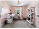 Bright home office featuring neutral pink walls, a desk, bookcase, and a cozy sitting area at 2401 Morninglight Dr, Lutz, FL 33558