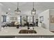 Open concept kitchen with granite countertops, stainless steel sink, and stylish lighting fixtures at 2401 Morninglight Dr, Lutz, FL 33558