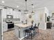 Modern kitchen with white cabinets, black appliances, an island with seating and stylish pendant lights at 2401 Morninglight Dr, Lutz, FL 33558