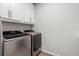 Bright laundry room with modern washer and dryer, and white cabinets for ample storage space at 2401 Morninglight Dr, Lutz, FL 33558