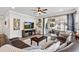 Cozy living room showcasing a ceiling fan, entertainment center, and comfortable seating area at 2401 Morninglight Dr, Lutz, FL 33558