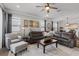 Bright living room featuring a comfortable leather sofa, accent chair, and stylish wood flooring at 2401 Morninglight Dr, Lutz, FL 33558