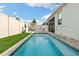 Enjoy the serene backyard with a refreshing pool, manicured lawn, and inviting patio area at 2401 Morninglight Dr, Lutz, FL 33558