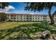 Well-maintained condo building featuring a red tile roof, balconies, and landscaped lawn at 2700 Bayshore Blvd # 2110, Dunedin, FL 34698